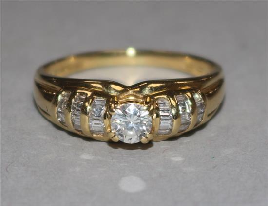 An 18ct gold and diamond ring, the central stone approx 0.25ct, flanked by baguette-set shoulders, 4.1gr gross.